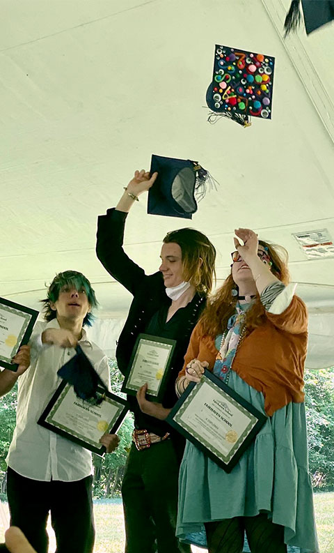 fairhaven school graduates throwing caps in the air